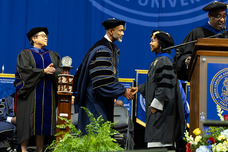 Graduate commencement graduate shaking chancellor's hand