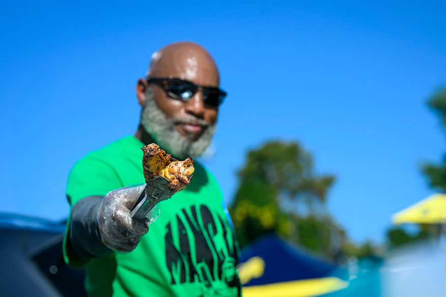 male alumnus grilling chicken on campus